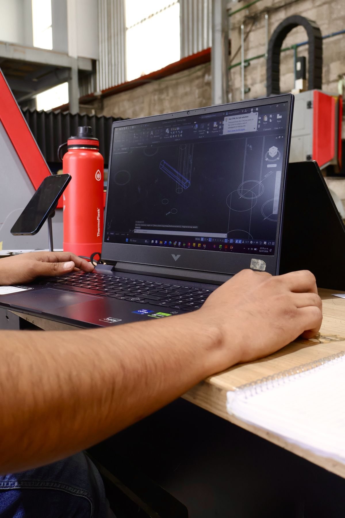 Ingeniero de Rolacero Multiprocesos modelando una pieza en 3D en laptop