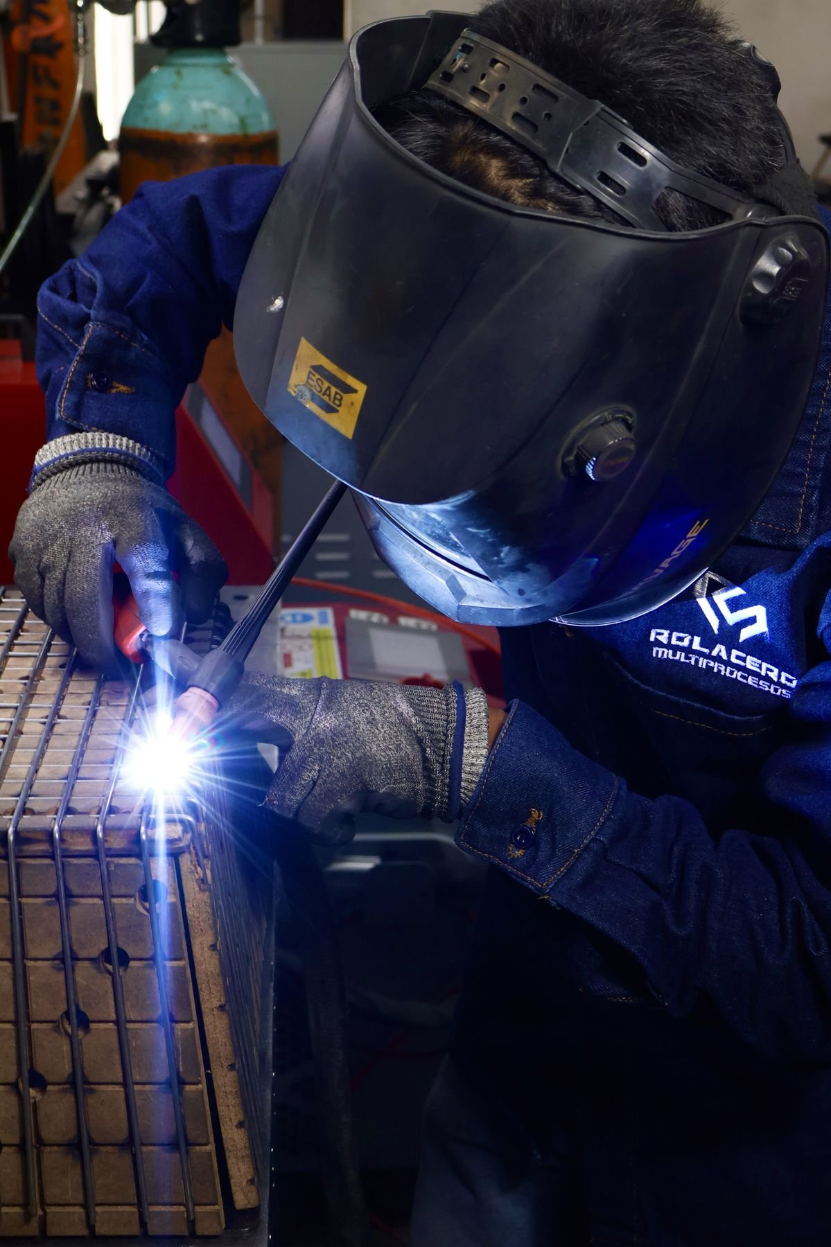 Soldador de Rolacero Multiprocesos con careta ESAB soldando una estructura metálica